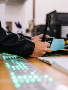 Man working on circuit board with soldering iron