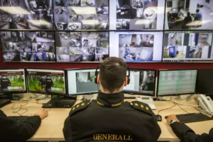 Vigilante monitorando câmeras de segurança de condomínio com portaria inteligente