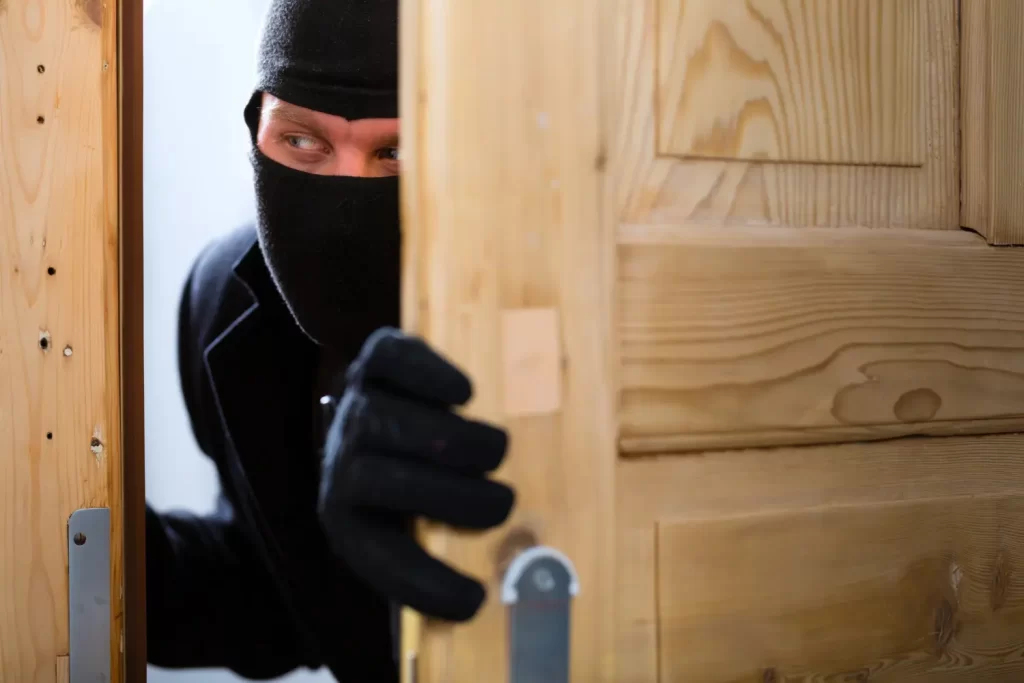 Ladrão encapuzado abre porta de apartamento durante invasão em condomínio