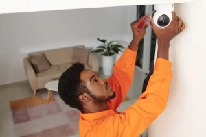 Homem instalando câmeras de segurança residencial em sua casa